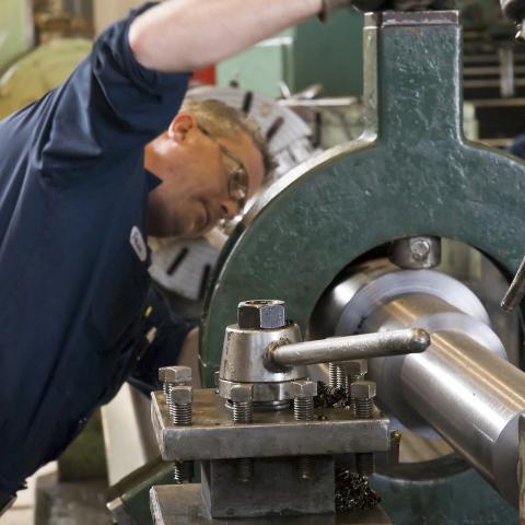 Technician operating lathe in Dynamic Machine Corp's machine shop